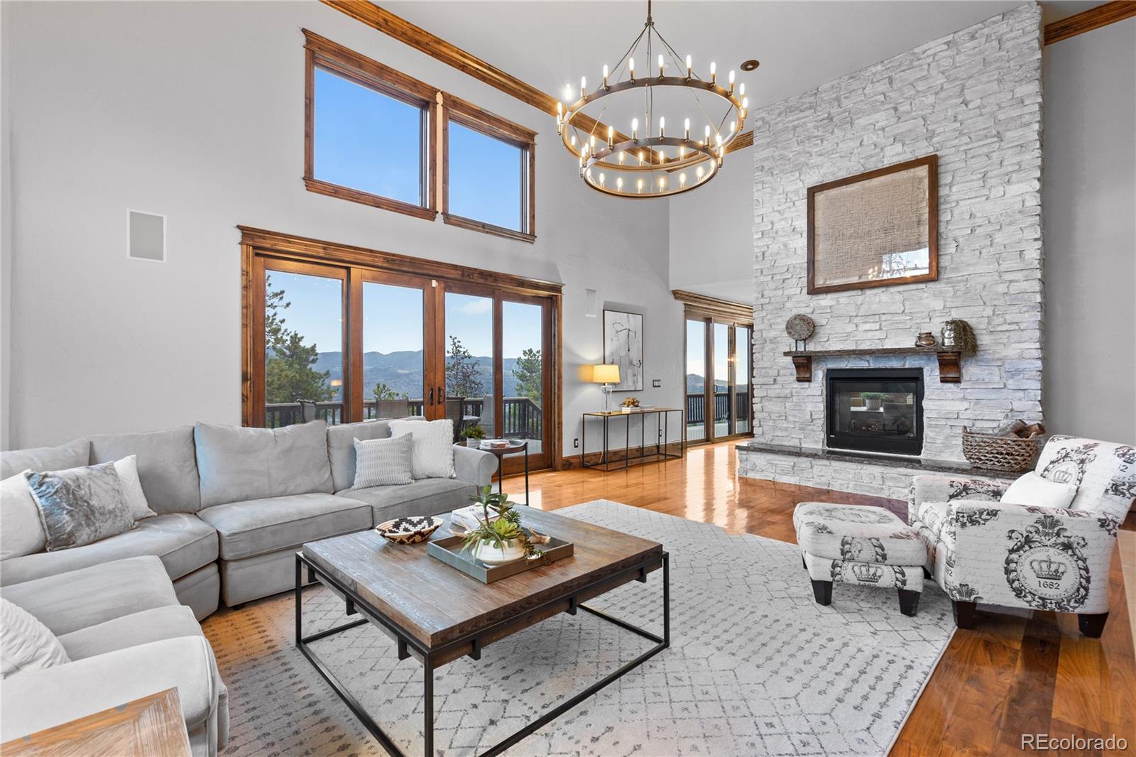 100 Halter Way Evergreen, CO 80439 - Photo 9 of 40 a living room with furniture a fireplace a chandelier and a flat screen tv