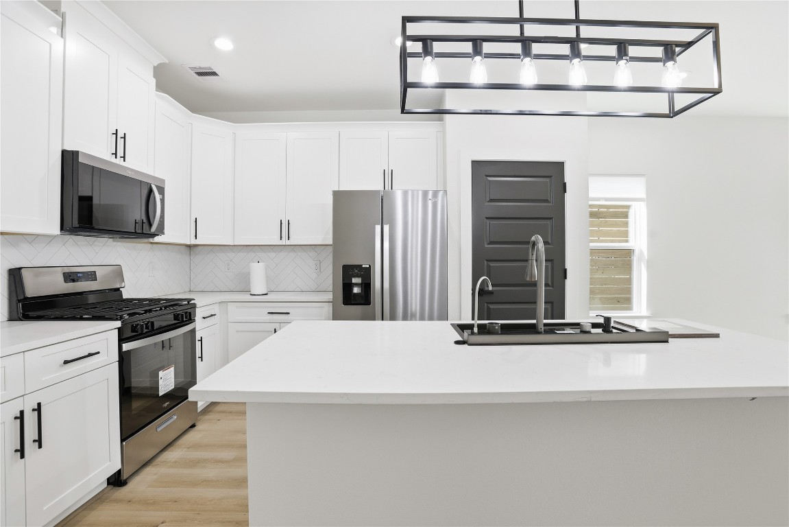 a kitchen with stainless steel appliances a sink stove and refrigerator