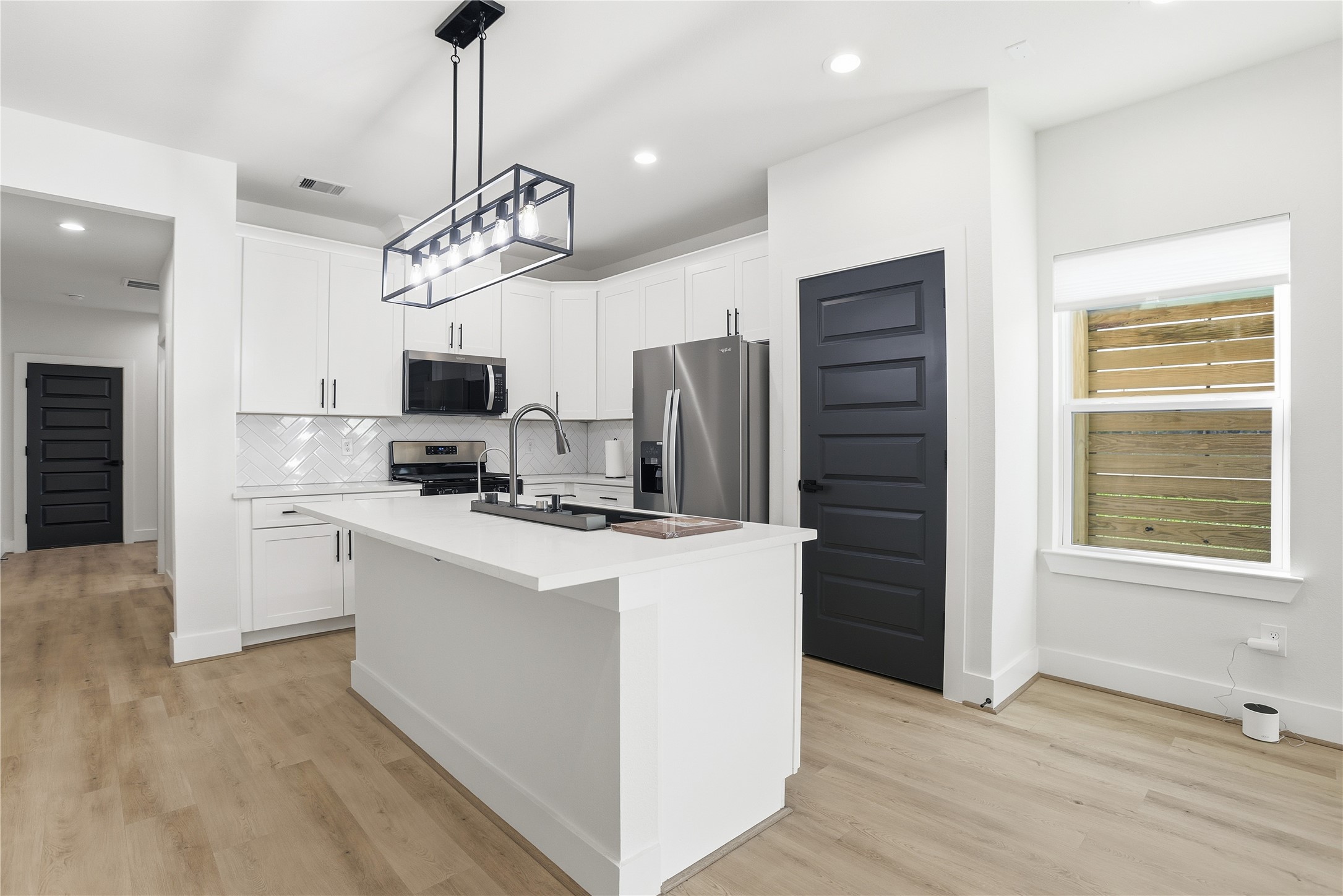 712 Delano Street, Unit A Houston, TX 77003 - Photo 5 of 35 a kitchen with stainless steel appliances a stove a refrigerator and a chandelier