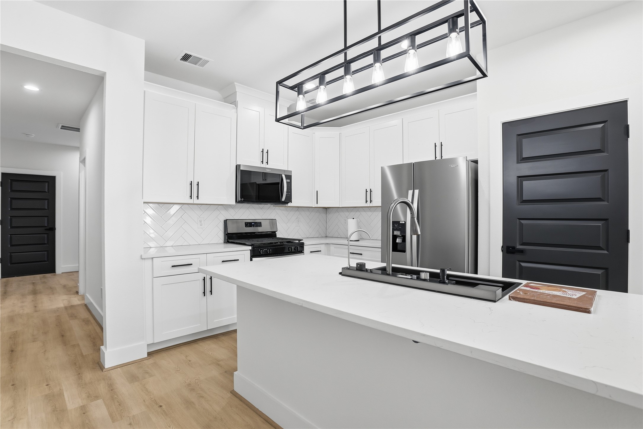 712 Delano Street, Unit A Houston, TX 77003 - Photo 6 of 35 a kitchen with stainless steel appliances a refrigerator and microwave
