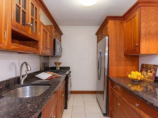 6 Whittier Place, Unit 9E Boston, MA 02114 - Photo 2 of 24 a kitchen with granite countertop a sink and a stove top oven