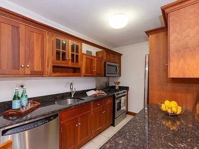 a kitchen with stainless steel appliances granite countertop a sink stove and cabinets