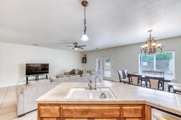 a kitchen with stainless steel appliances granite countertop a stove a sink and a microwave