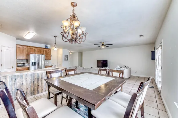 a dining room with furniture a chandelier and window
