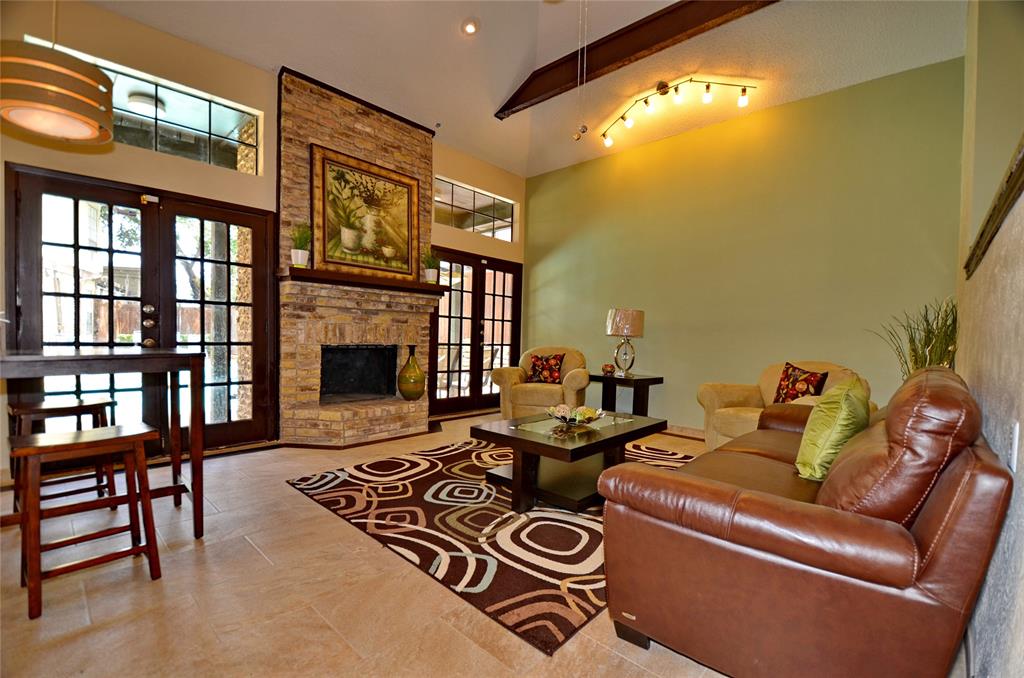 5630 Spring Valley Road, Unit 17A Dallas, TX 75254 - Photo 12 of 14 a living room with furniture a fireplace and a flat screen tv
