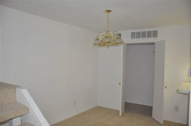 a view of empty room with a chandelier fan