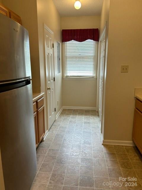 19940 Oak Leaf Circle Cornelius, NC 28031 - Photo 17 of 21 a view of a refrigerator in kitchen and an empty room with wooden floor
