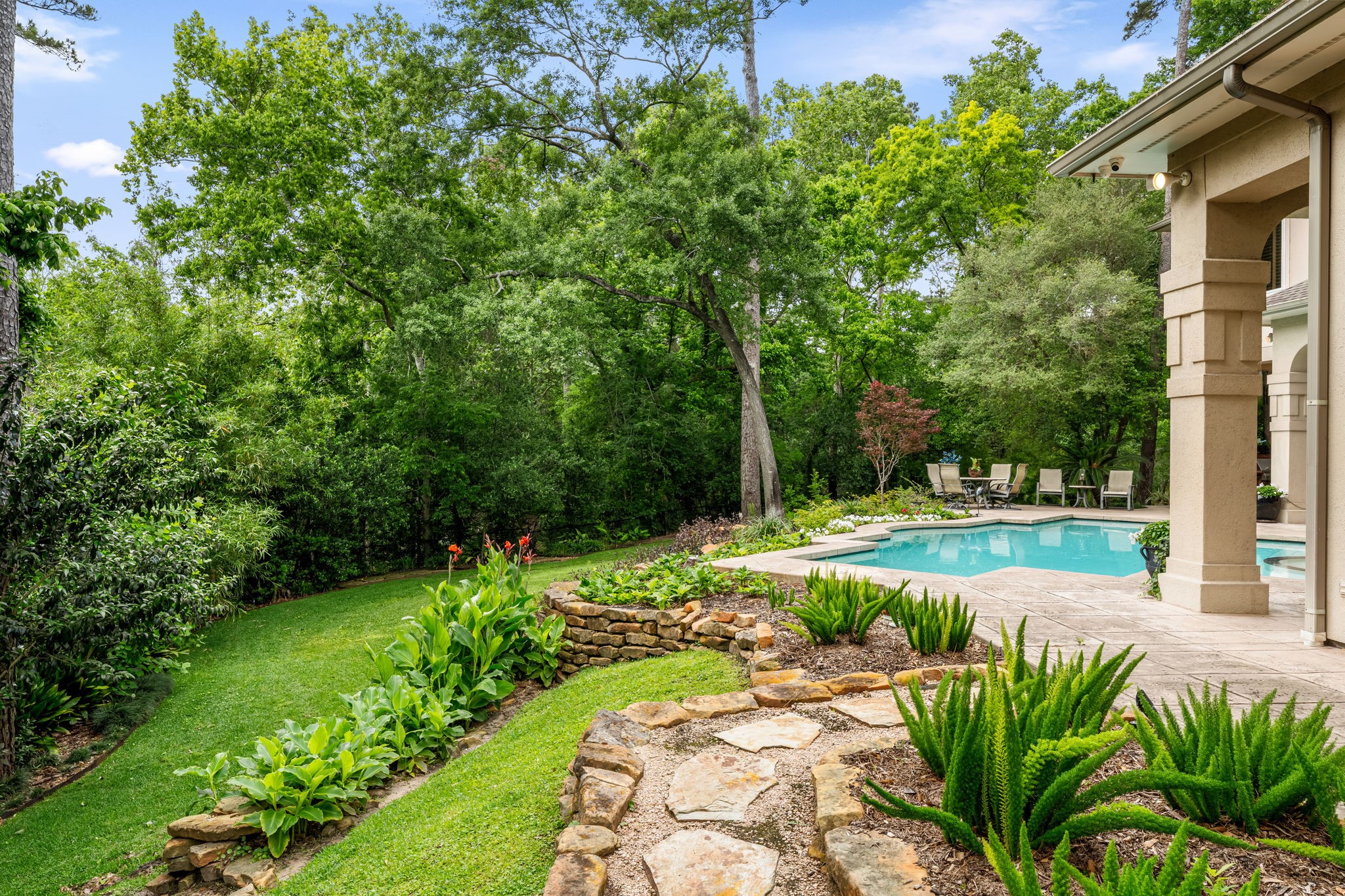 6 Mott Lane Houston, TX 77024 - Photo 2 of 50 Lush, private backyard oasis featuring manicured landscaping, mature trees, and a winding stone pathway leading to the pool.