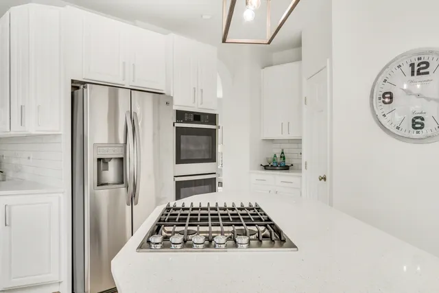a kitchen with stainless steel appliances a sink stove and refrigerator