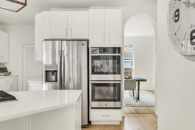 a kitchen with white cabinets and a stove