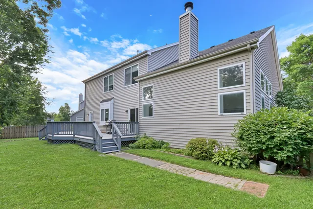 an aerial view of a house with a yard and a large tree