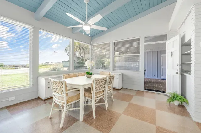 a dining room with furniture a chandelier and a large window
