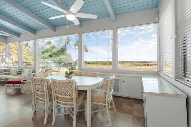 a view of a dining room with furniture large windows and wooden floor