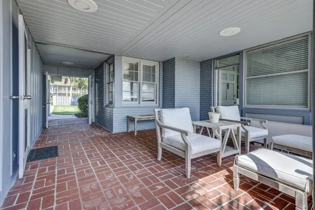 a view of a patio with couple of chairs and a rug