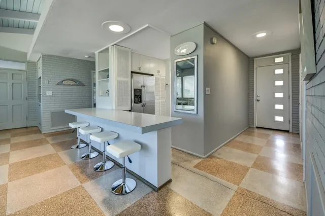 a view of a hallway with furniture and view of bathroom