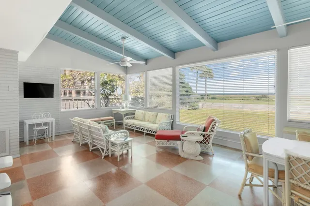 a living room with furniture and floor to ceiling windows