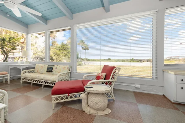 a living room with patio furniture and a large window