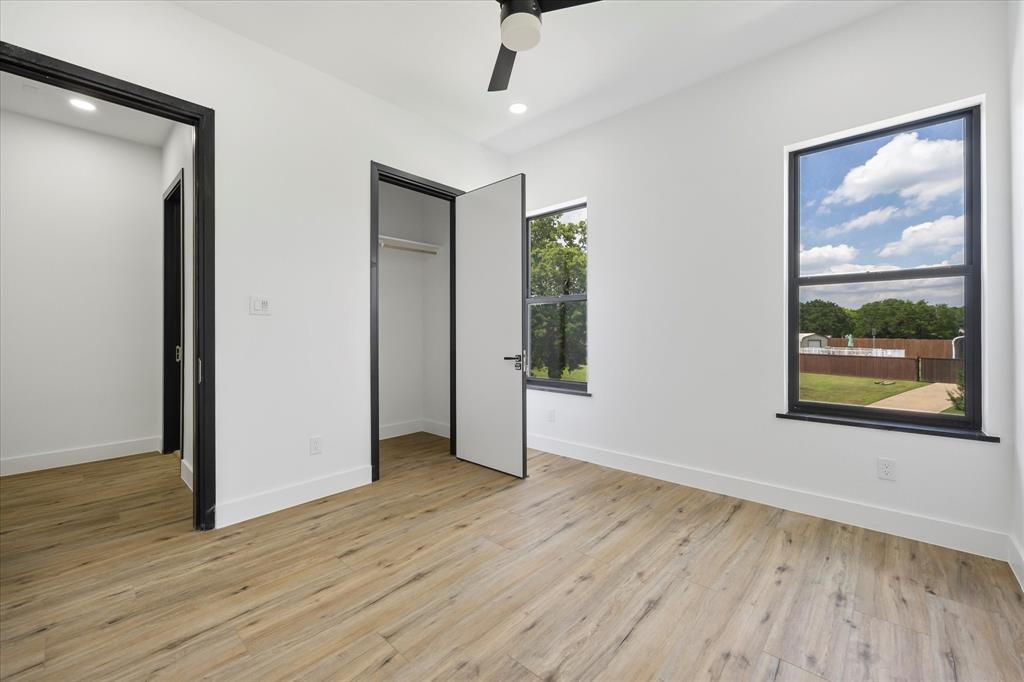 2811 Rodeo Drive Quinlan, TX 75474 - Photo 17 of 38 an empty room with wooden floor and windows