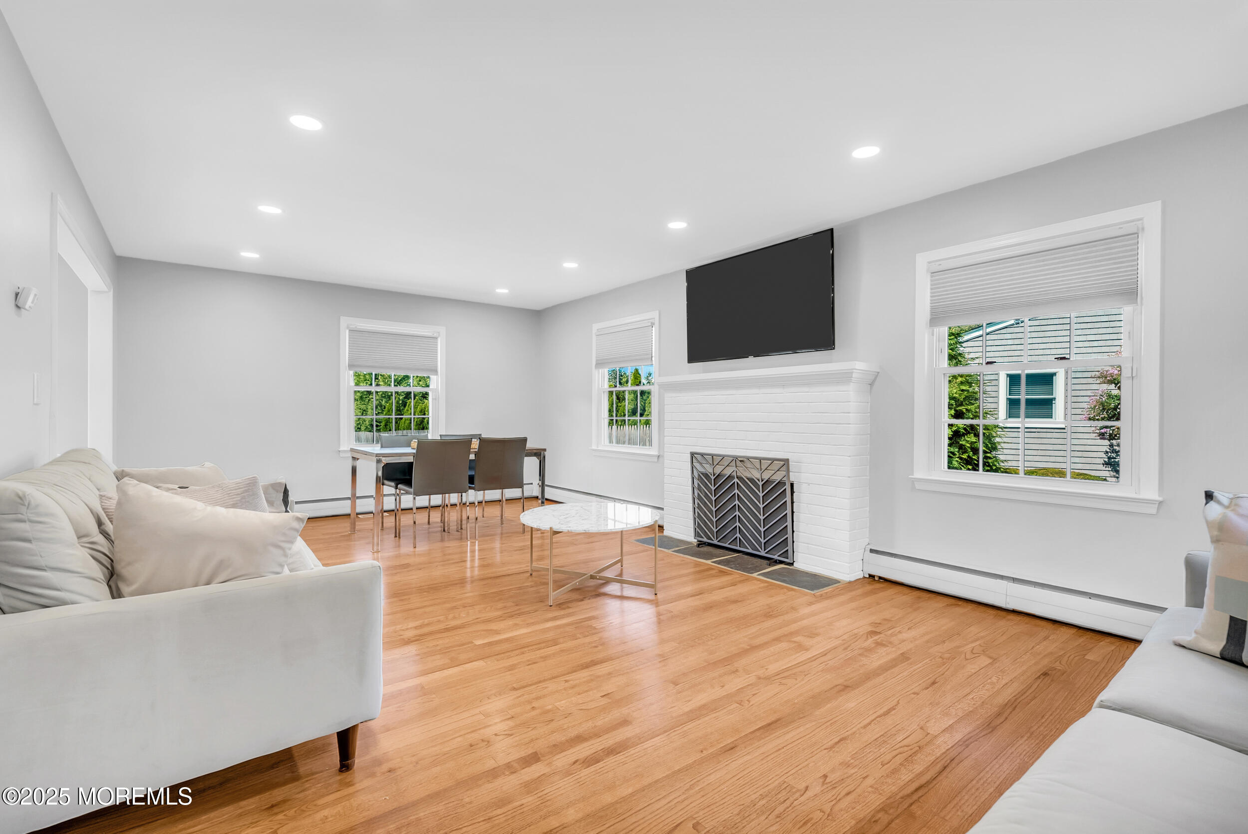 11 Pinewood Avenue West Long Branch, NJ 07764 - Photo 17 of 39 a living room with furniture a fireplace and a flat screen tv