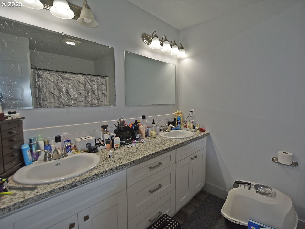 306 Oak Street Winlock, WA 98596 - Photo 25 of 35 a bathroom with a granite countertop sink double vanity and mirror