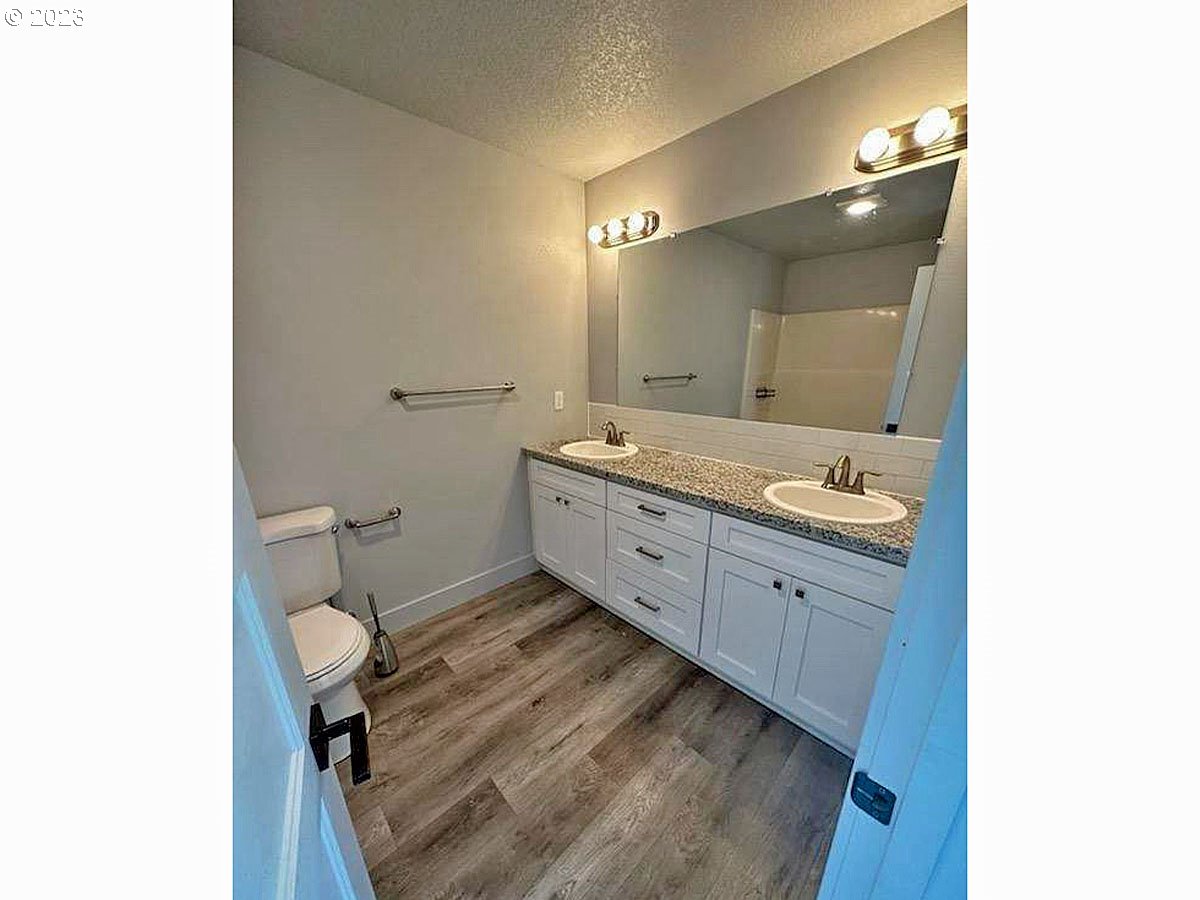 306 Oak Street Winlock, WA 98596 - Photo 26 of 35 a spacious bathroom with a granite countertop sink a toilet and a mirror