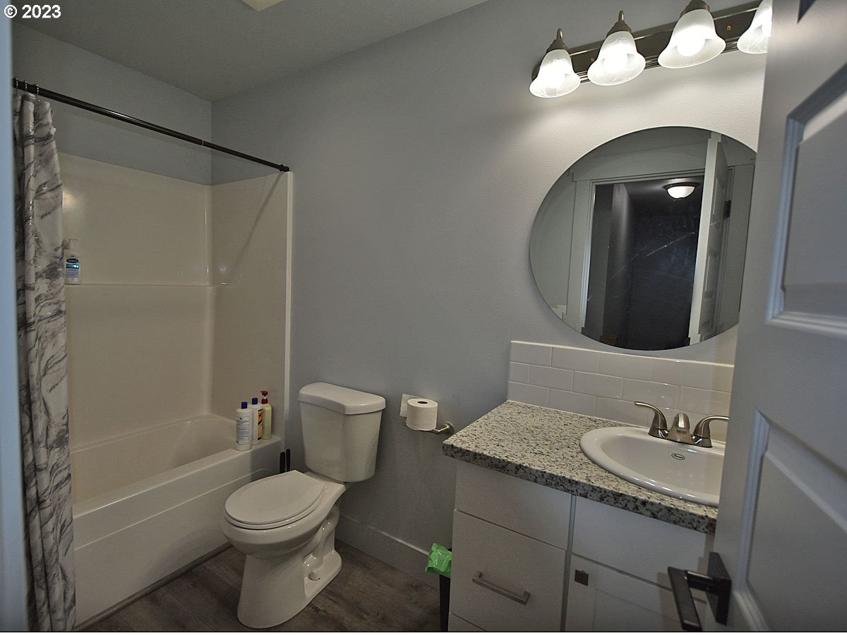 306 Oak Street Winlock, WA 98596 - Photo 31 of 35 a bathroom with a granite countertop sink mirror vanity and toilet