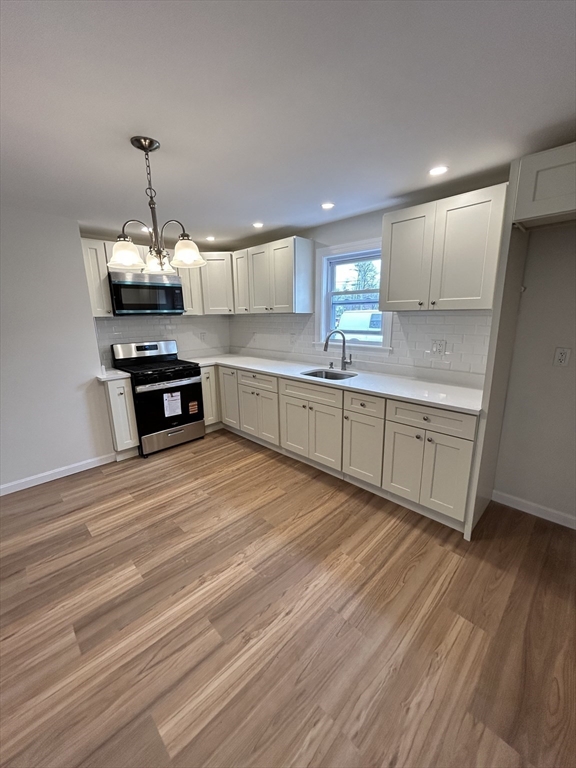 0 Main Street, Unit 1 Brockton, MA 02301 - Photo 2 of 9 a kitchen with granite countertop a stove a sink and a refrigerator