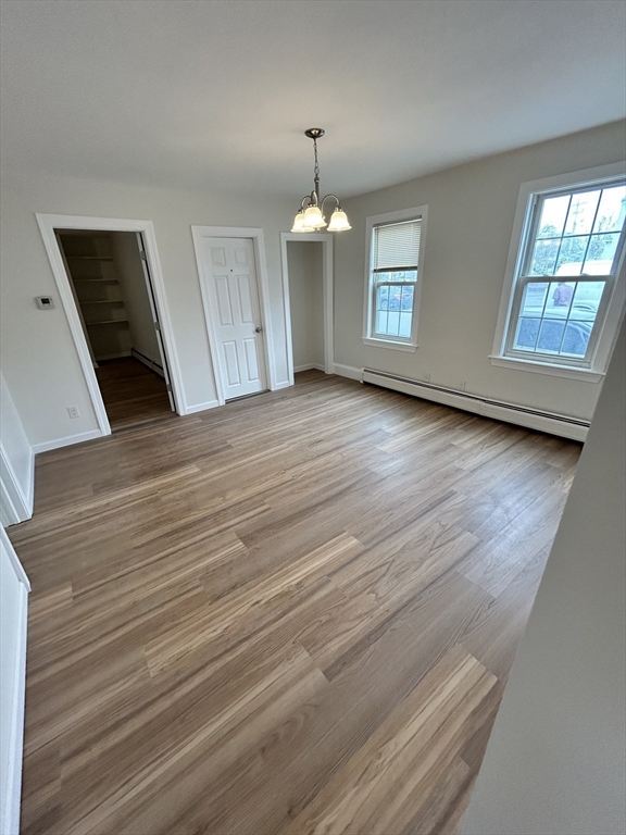 0 Main Street, Unit 1 Brockton, MA 02301 - Photo 5 of 9 an empty room with wooden floor windows and hallway