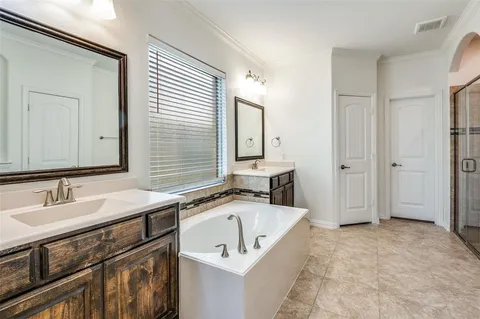 a bathroom with a tub sink and mirror