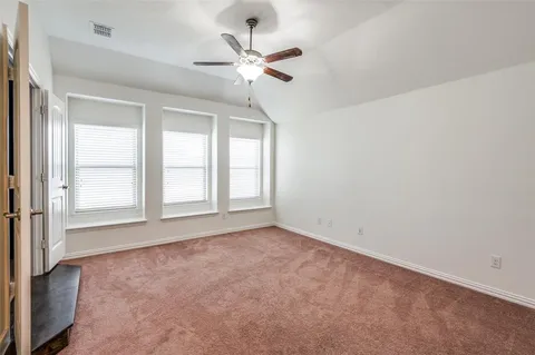 an empty room with window and ceiling fan