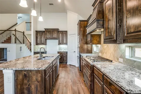 a kitchen with stainless steel appliances granite countertop a sink stove and refrigerator