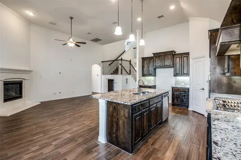 a kitchen with a stove and a wooden floor