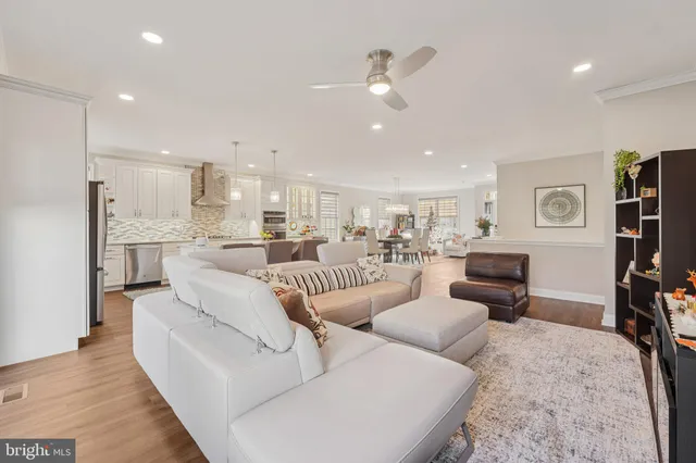 a living room with furniture and a dining table with kitchen view