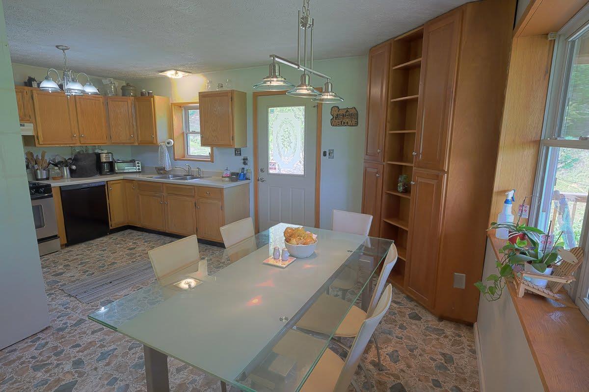 2341 Adamson Branch Road Liberty, TN 37095 - Photo 7 of 18 a kitchen view with granite countertop a refrigerator a stove a sink a dining table and chairs