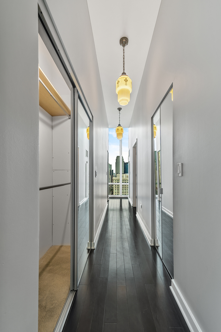 611 South Wells Street, Unit 3102 Chicago, IL 60607 - Photo 15 of 33 a view of hallway with chandelier and wooden floor