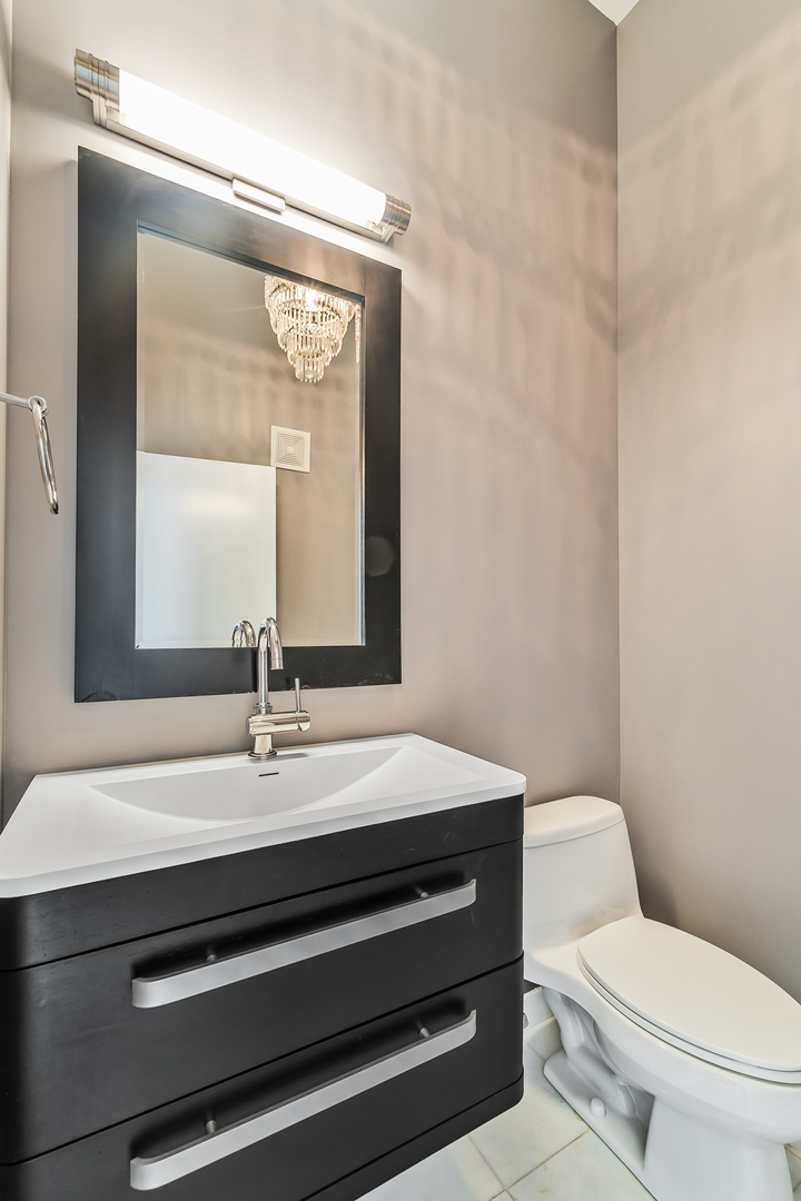 611 South Wells Street, Unit 3102 Chicago, IL 60607 - Photo 25 of 33 a bathroom with a sink vanity mirror and toilet