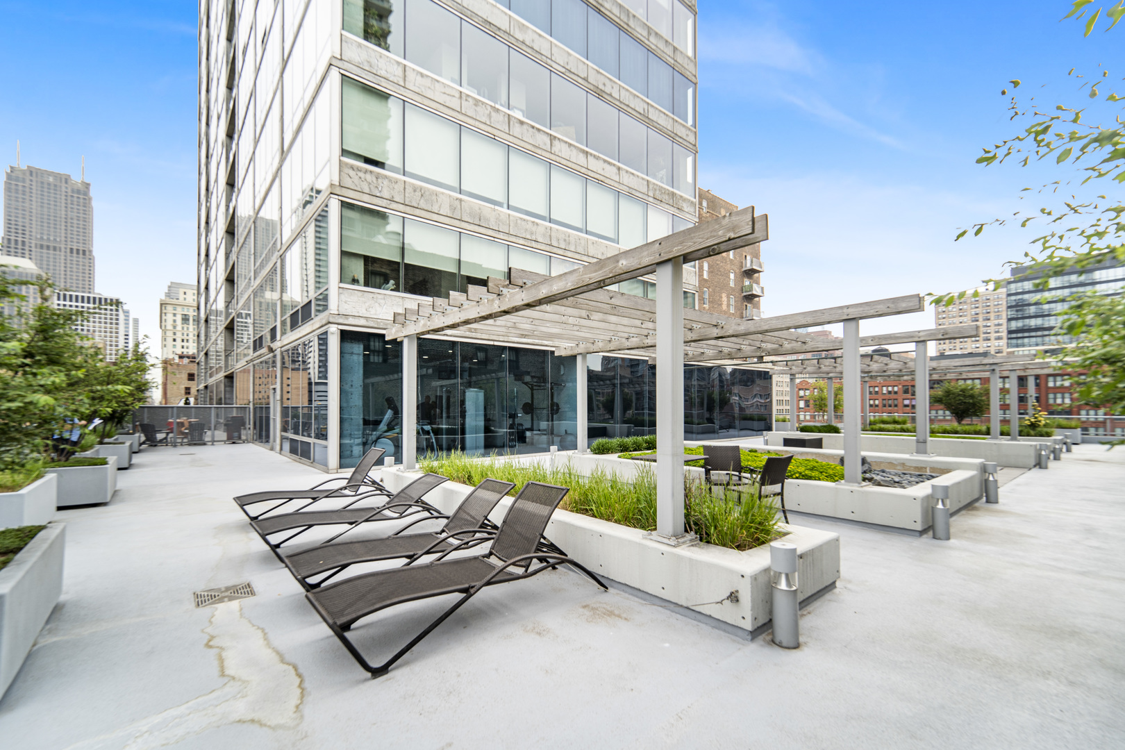 611 South Wells Street, Unit 3102 Chicago, IL 60607 - Photo 32 of 33 a view of a patio with couches table and chairs with a small yard