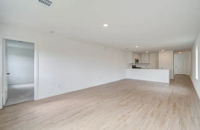 a view of empty room with wooden floor