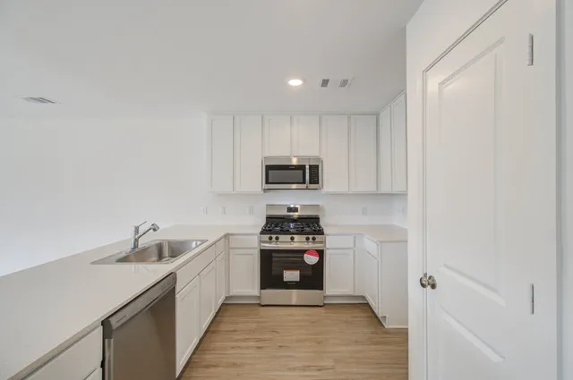 a kitchen with sink a stove and cabinets