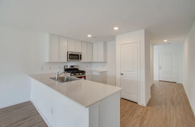 a kitchen with sink a microwave and cabinets