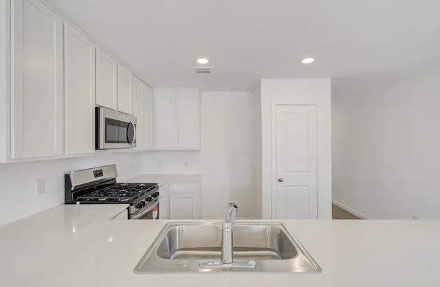 a kitchen with a sink a stove and a refrigerator