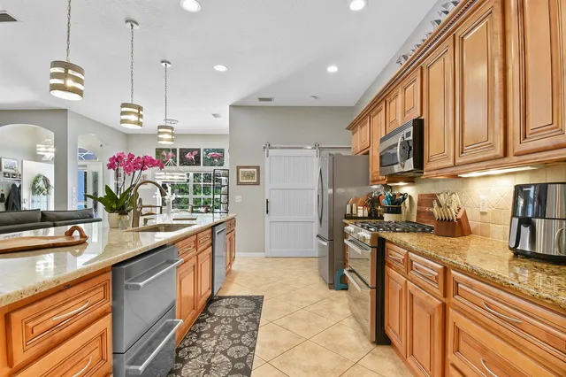 a kitchen with stainless steel appliances granite countertop a sink stove and refrigerator