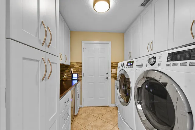 a bedroom with a large bed a chandelier and windows