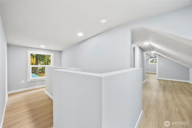 a view of a big room with wooden floor and windows