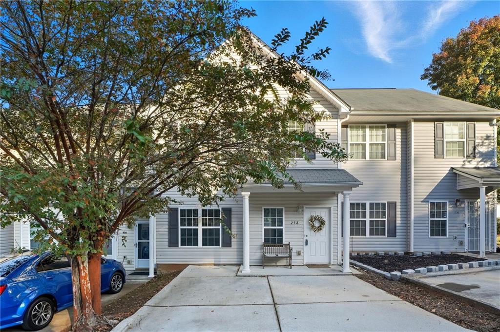 a front view of a house with a tree
