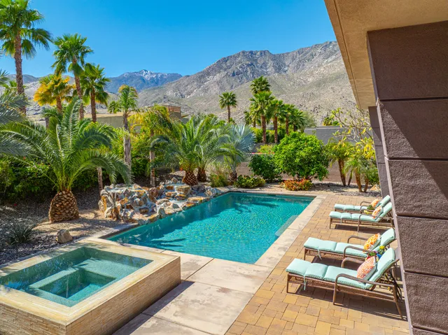 a view of swimming pool with lounge chair and fire pit