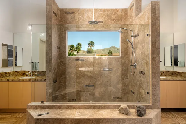 a spacious bedroom with a bed couch and a flat tv screen