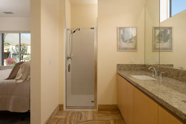 a bedroom with a bed and painting on the wall