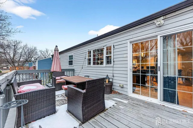 a view of a patio with couches and table and chairs with wooden floor and fence