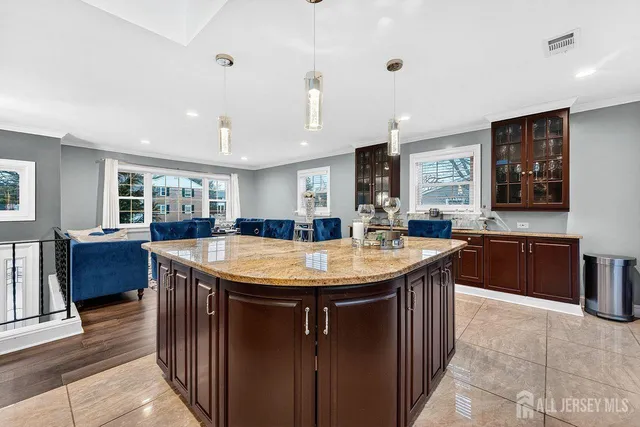 a room with stainless steel appliances granite countertop a sink a counter space and wooden floor